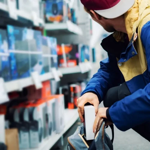Close up image of a shoplifter taking electronic goods